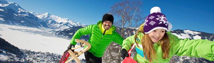 Vater und Tochter beim Schlittenfahren